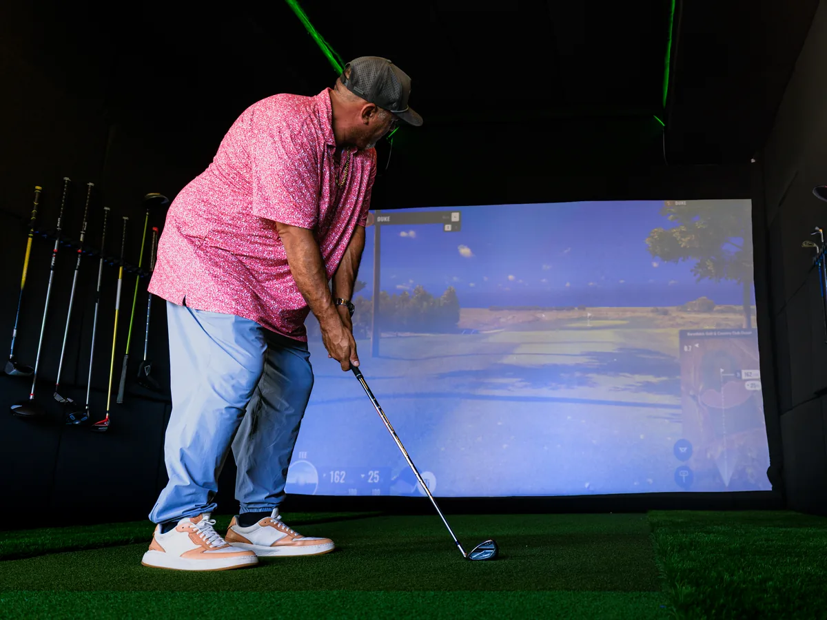 Daren Kawika Martin set up over the ball inside the trailer with a course view on the TrackMan screen