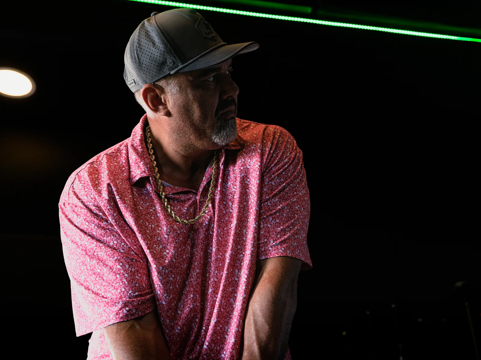 Daren Kawika Martin, founder of SwingLab Hawaii, inside the simulator trailer under the green LED strip
