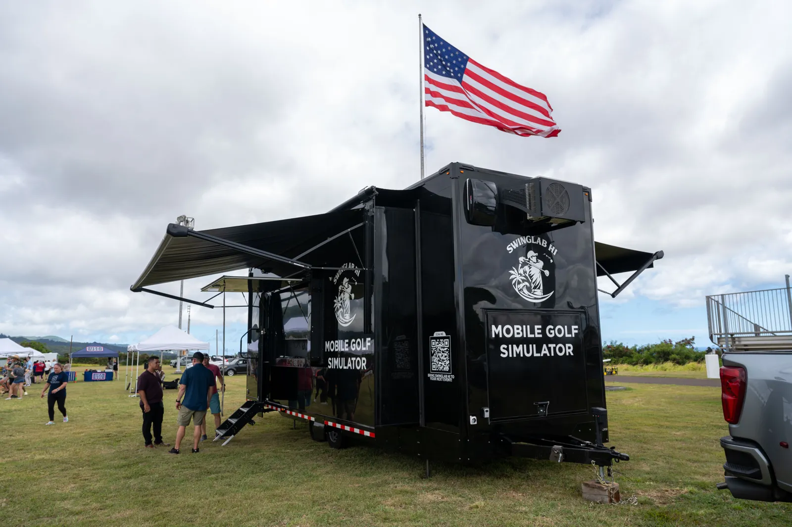 The SwingLab trailer set up at a private outdoor event, awnings out