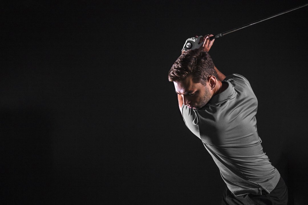 A player at full extension during a TrackMan simulator swing